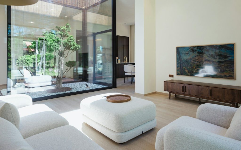 Salon moderne avec vue sur la cour et télévision.